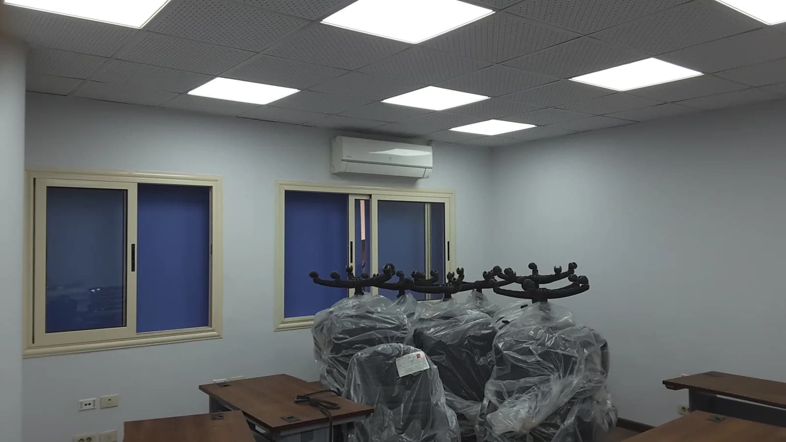 غرفة مكتب مكتملة بإضاءة LED في السقف ومكيّف